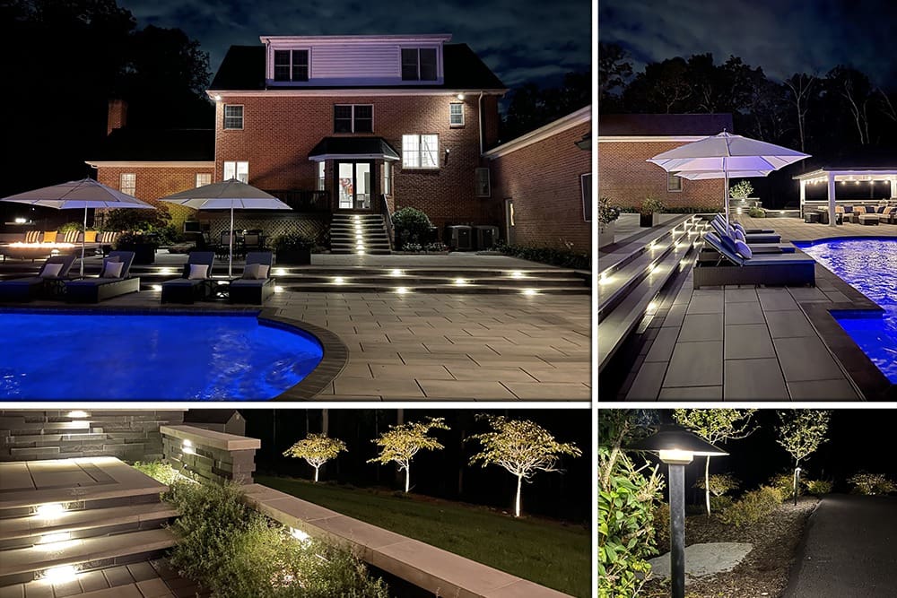 A well-lit backyard at night featuring a red-brick house. The yard has a pool, lounge area with umbrellas, and various illuminated steps and pathways with manicured trees. The pool glows blue, and the landscape lighting adds a serene ambiance.